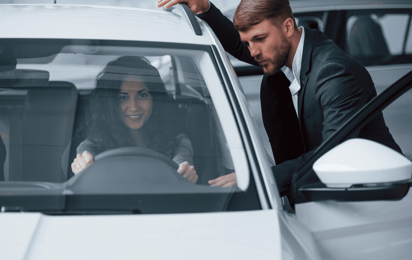 Customer signing documents at a car dealership